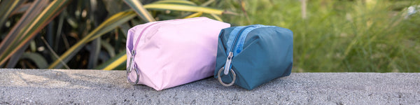 Woman lying in confetti surrounded by gift boxes, featuring a solid black purse.