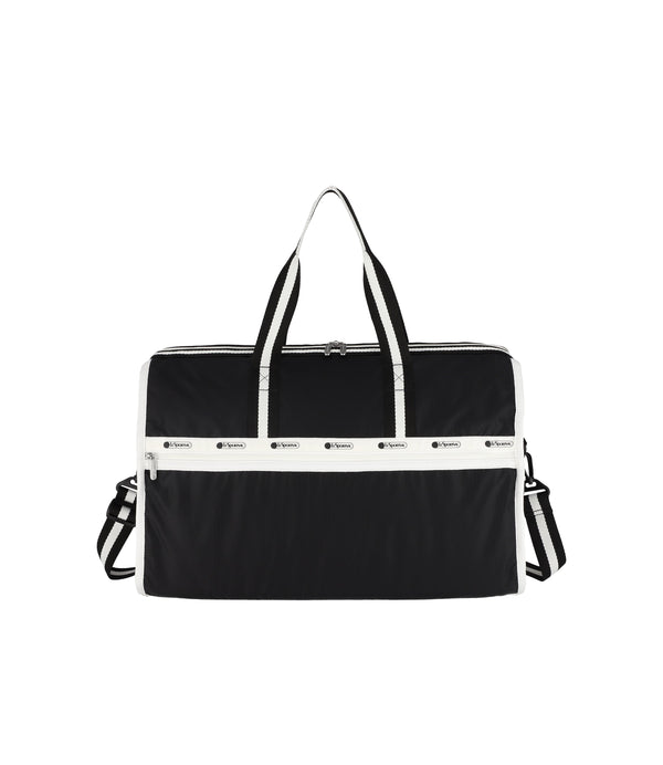 Deluxe Large Weekender in black with white trim, featuring a dual-zip main closure, detachable crossbody strap, and multiple zip pockets.